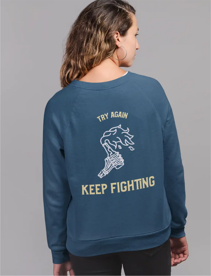 a female model wearing navy blue sapienwear women's sweatshirt with the keep fighting graphic on the back side.