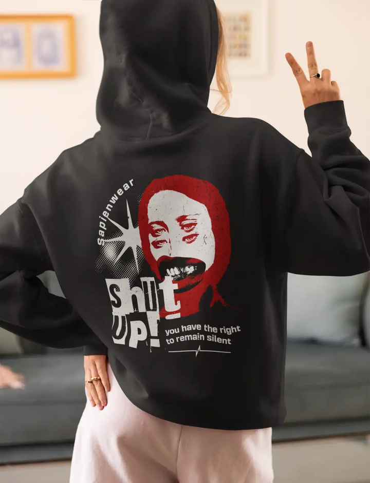 a female model wearing a black sapienwear women's hoodie with the "shut up" graphic on the back side